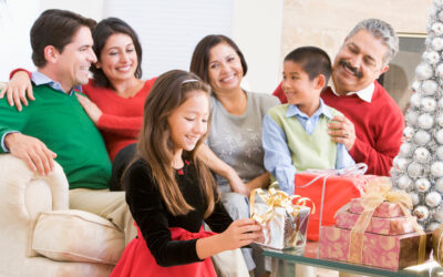 Family Sitting On Sofa In Front Of Christmas Presents,Young Girl